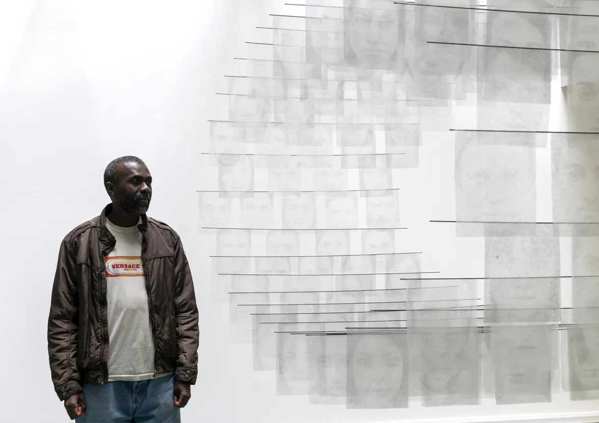 Un résident du centre d'hébergement Goncourt devant l'oeuvre Missingu de Laurent Lafolie, 2023